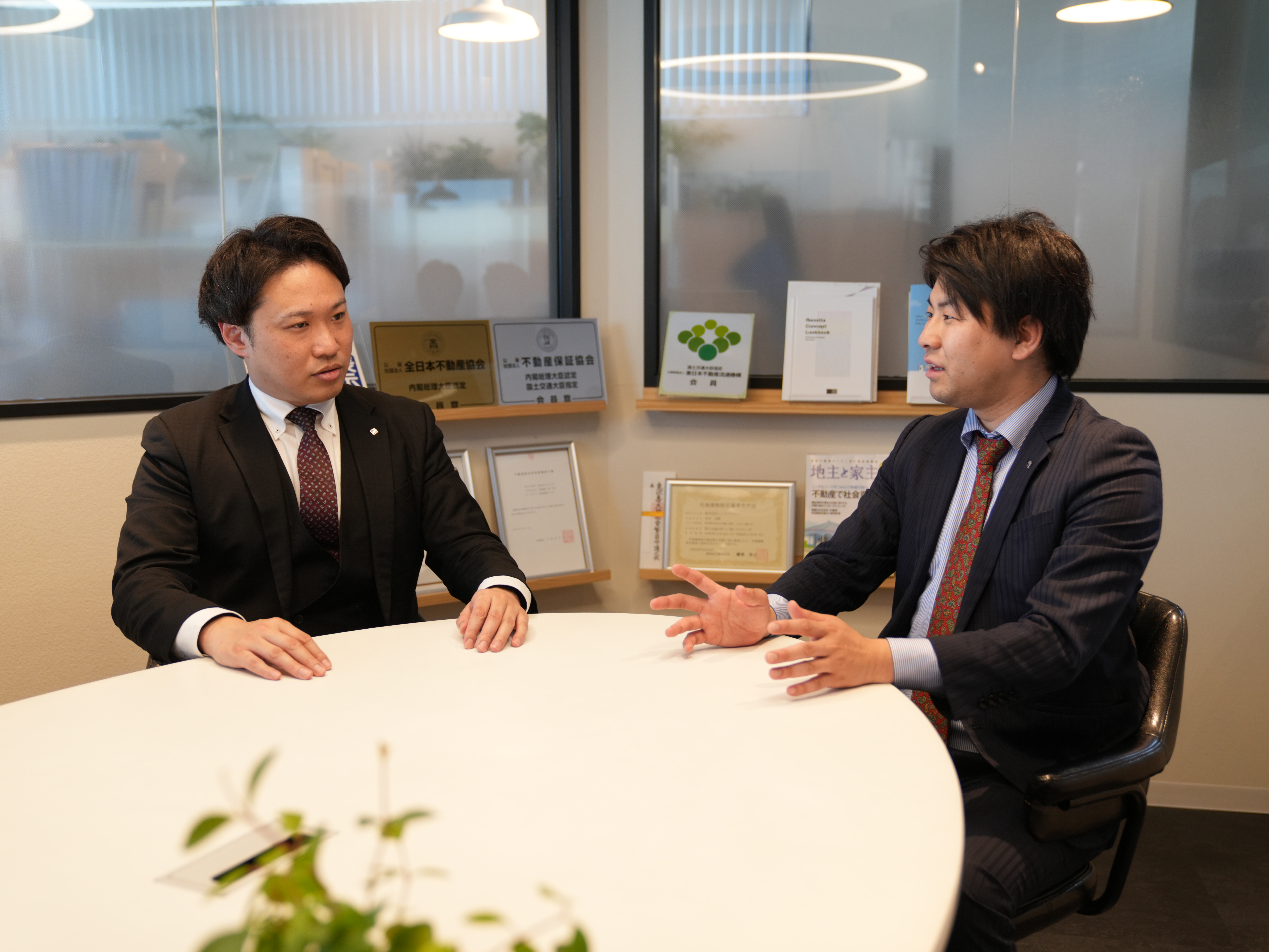 スーツを着ている男性2人が会話をしている様子
